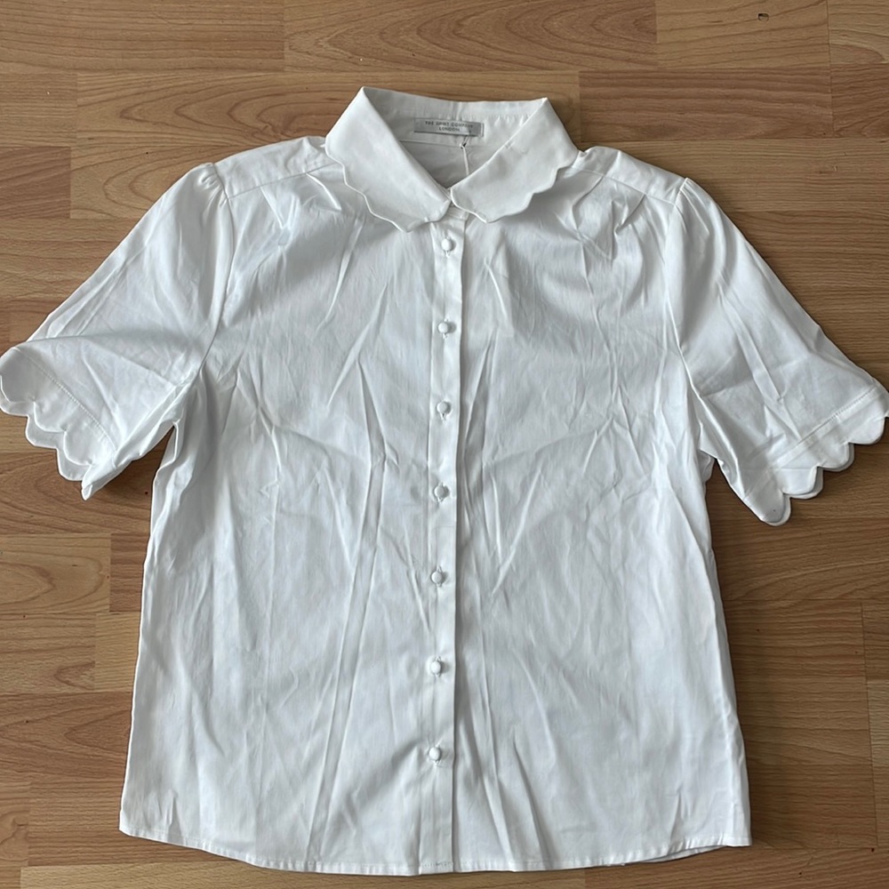 White button down with scallop detail on collar and sleeves.